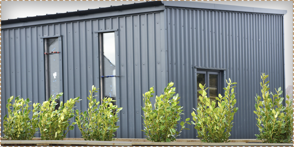 A picture of the hedge and fused glass art showroom outside of our Anglesey bed and breakfast. This image is being used as a blog header.